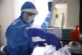 Nhân viên tiến hành xét nghiệm mẫu bệnh phẩm COVID-19 tại phòng thí nghiệm ở Warsaw, Ba Lan ngày 14/5/2020. (Ảnh: PAP/TTXVN)