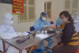 Lấy mẫu xét nghiệm nhanh virus SARS-CoV-2 cho tiểu thương chợ đầu mối. (Ảnh: TTXVN/phát)
