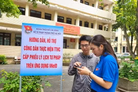 Đoàn viên thanh niên Sở Tư pháp hướng dẫn công dân thực hiện cấp Phiếu Lý lịch tư pháp trên VNeID. (Ảnh: Kim Anh/TTXVN)