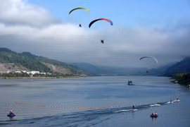 Dòng Nậm Na sôi động bởi cuộc đua thuyền và trình diễn dù lượn, lướt ván. (Ảnh: Trung Kiên/TTXVN)
