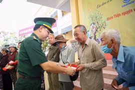 Đại tá Phạm Đình Triệu, Chính ủy Bộ đội Biên phòng Tây Ninh tặng quà cho người dân vùng biên giới. (Ảnh: Giang Phương/TTXVN)