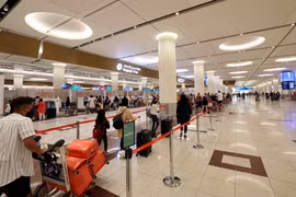 Hành khách làm thủ tục tại Sân bay Quốc tế Dubai. (Ảnh: AFP/TTXVN)