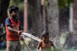 Trẻ em chơi đùa với nước trong ngày nắng nóng tại New Delhi, Ấn Độ, ngày 31/5. (Ảnh: AFP/TTXVN)