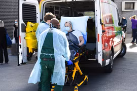 Chuyển bệnh nhân COVID-19 lên xe cứu thương tại thành phố Melbourne, bang Victoria, Australia ngày 29/7/2021. (Ảnh: AFP/TTXVN)