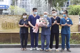 Êkíp bác sỹ, điều dưỡng điều trị ca bệnh của Bệnh viện Thanh Nhàn tặng hoa chúc mừng bệnh nhân H.V.N (giữa) khỏi bệnh, ra viện ngày 17/9. (Ảnh: Minh Quyết/TTXVN)