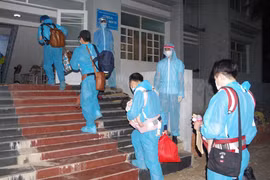 Công dân Việt Nam từ nước ngoài trở về được các nhân viên y tế hướng dẫn vào khu cách ly. (Ảnh: Chanh Đa/TTXVN)
