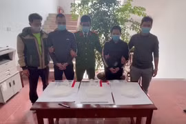 Hai đối tượng cùng tang vật tại cơ quan công an. (Ảnh: Đinh Tuấn/TTXVN)