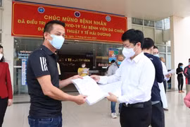Ông Trần Trọng Khoa, Phó Cục trưởng Cục khám chữa bệnh, Bộ Y tế trao giấy ra viện cho bệnh nhân ra viện lần này. (Ảnh: Mạnh Minh/TTXVN)