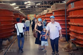 Khách du lịch tham quan khu sản xuất nước mắm tại Nhà thùng nước mắm Khải Hoàn trên đảo Phú Quốc. (Ảnh: Lê Huy Hải/TTXVN)
