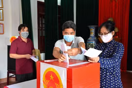 Cử tri là giáo dân tại xã Xuân Ngọc, huyện Xuân Trường, tỉnh Nam Định đi bầu cử ngày 23/5. (Ảnh: Công Luật/TTXVN)