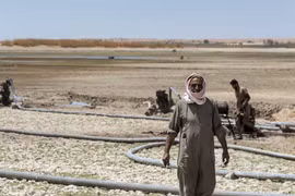 Người dân lấy nước sinh hoạt tại một hồ chứa gần khô cạn cạnh sông Euphrates ở tỉnh Raqqa, miền Đông Syria ngày 27/7/2021. (Ảnh: AFP/TTXVN)
