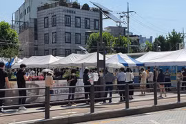 Người dân xếp hàng xét nghiệm COVID-19 trong thời tiết nắng nóng ở quận Seongbuk, Seoul. (Ảnh: Mạnh Hùng/TTXVN)