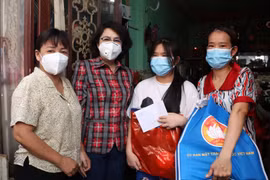 Chủ tịch Ủy ban MTTQ Thành phố Hồ Chí Minh Tô Thị Bích Châu thăm hỏi và tặng quà cho các em mồ côi vì COVID-19 tại Quận 4. (Ảnh: Thu Hương/TTXVN)