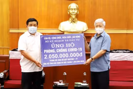 Chủ tịch Ủy ban Trung ương Mặt trận Tổ quốc Việt Nam Đỗ Văn Chiến tiếp nhận ủng hộ Quỹ vaccine phòng COVID-19 từ Bộ trưởng Bộ Kế hoạch và Đầu tư Nguyễn Chí Dũng. (Ảnh: Minh Đức/TTXVN)