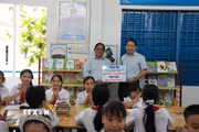 Ông Nguyễn Việt Dũng, Bí thư Đảng ủy, Giám đốc Trung tâm Thông tin TTXVN khu vực miền Trung-Tây Nguyên và Hiệu trưởng trường Tiểu học Tây Nha Trang bên tủ sách Đinh Hữu Dư trong thư viện của trường. (Ảnh: Nguyễn Dũng/TTXVN)