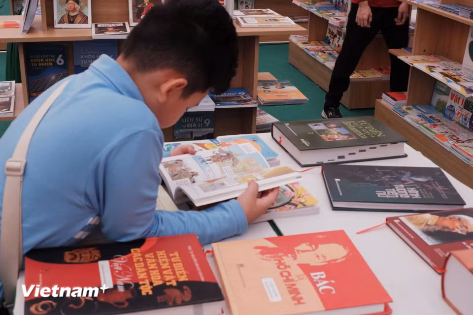 Các bạn nhỏ say mê với các cuốn sách được trưng bày tại gian hàng của Nhà xuất bản Giáo dục Việt Nam. (Ảnh: Phương Trang/Vietnam+)