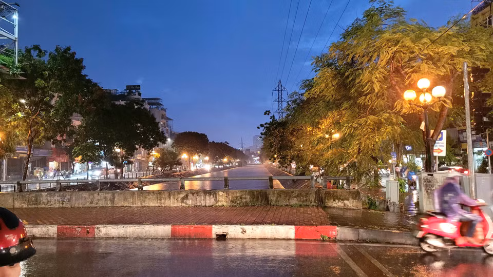 Mưa lớn xối xả kéo dài khoảng một giờ khiến nước đổ xuống sông Kim Ngưu khiến mực nước dâng cao. (Ảnh: Minh Anh/Vietnam+)