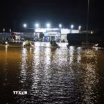 Các phương tiện gặp khó khăn khi lưu thông qua khu vực nước trên Quốc lộ 1A. (Ảnh: Phạm Cường/TTXVN)