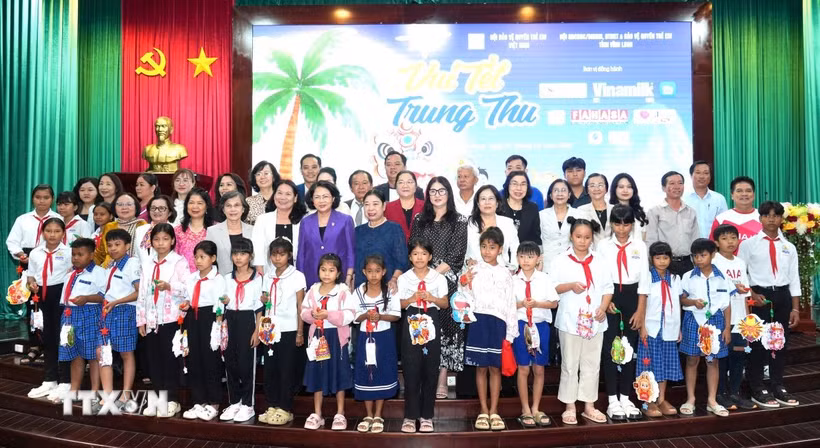Các đại biểu và đơn vị đồng hành và các em học sinh chụp ảnh lưu niệm tại chương trình. (Ảnh: Lê Thúy Hằng/TTXVN)