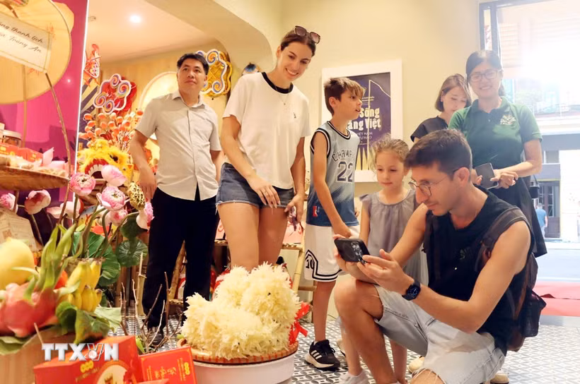 Du khách nước ngoài thích thú với những sản phẩm Trung Thu trưng bày tại chương trình. (Ảnh: Trần Việt/TTXVN)