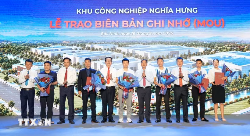 Lãnh đạo tỉnh Bắc Ninh và đại diện chủ đầu tư Khu công nghiệp Nghĩa Hưng tặng hoa chúc mừng các đơn vị tham gia ký kết biên bản ghi nhớ. (Ảnh: Đồng Thúy/TTXVN)