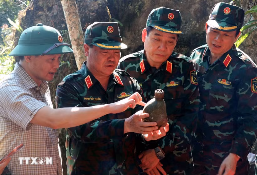 Thượng tướng Nguyễn Văn Gấu, Thứ trưởng Bộ Quốc phòng tỉ mỉ xem những vật dụng còn sót lại tại điểm cao 685. (Ảnh: Đức Thọ/TTXVN)