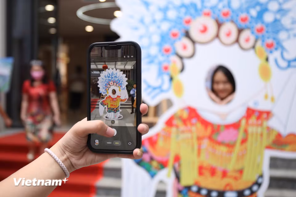 Các bạn trẻ thích thú chụp ảnh check-in tại sự kiện. (Ảnh: Trịnh Ngọc/Vietnam+)