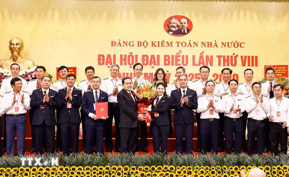Chủ tịch Quốc hội Trần Thanh Mẫn trao Quyết định và tặng hoa Phó Bí thư Đảng ủy, Phó Tổng Kiểm toán nhà nước Hà Thị Mỹ Dung. (Ảnh: Doãn Tấn/TTXVN)