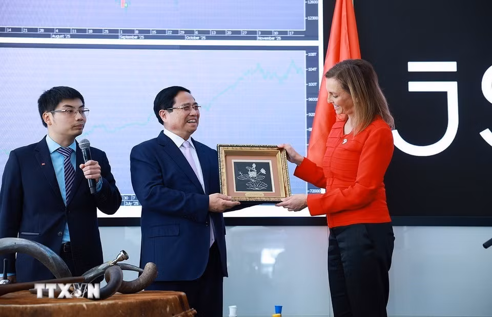 Thủ tướng Phạm Minh Chính tặng quà lưu niệm cho bà Leila Fourie, Giám đốc Thị trường Chứng khoán Johannesburg. (Ảnh: Dương Giang/TTXVN)