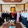 Tổng Lãnh sự Khamphay Phanthongdy trao lẵng hoa tươi thắm chúc mừng Tổng Lãnh sự Đinh Hoàng Linh, phu nhân và tập thể cán bộ nhân viên Tổng Lãnh sự quán Việt Nam. (Ảnh: PV/Vietnam+)