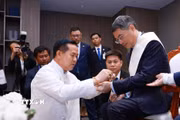 Thủ tướng Lê Minh Hưng thực hiện nghi thức buộc chỉ cổ tay truyền thống của Lào. (Ảnh: Dương Giang/TTXVN)